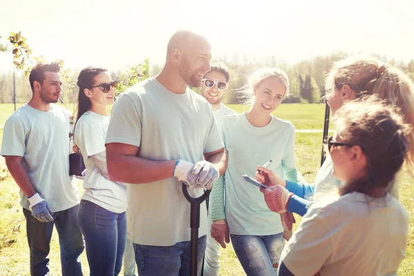 Grupo de voluntarios con plántulas de árboles en el parque —  Fotos de Stock