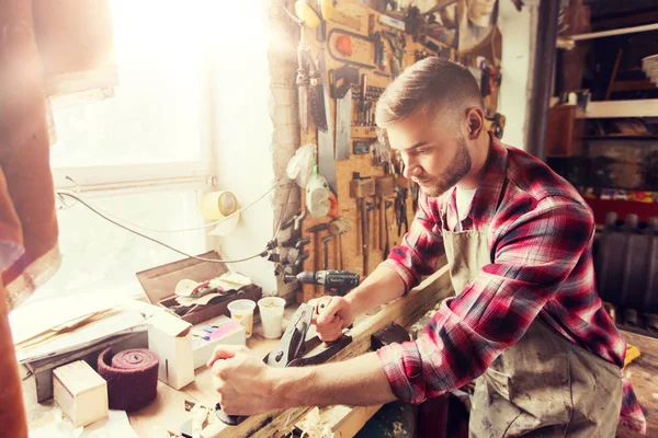 Menuisier travaillant avec avion et bois à l'atelier — Photo