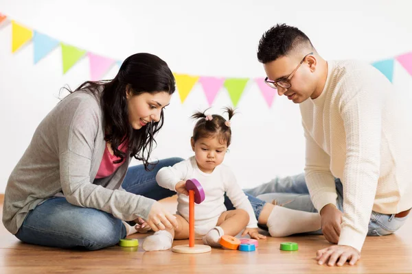 Holčička s rodiči hrát s hračkami, pyramida — Stock fotografie