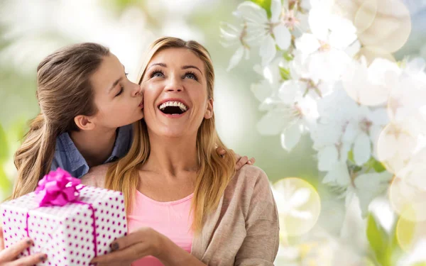 Дочка цілує маму і дарує їй подарунок — стокове фото