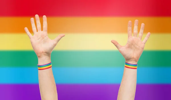 Manos con gay orgullo arco iris pulseras — Foto de Stock