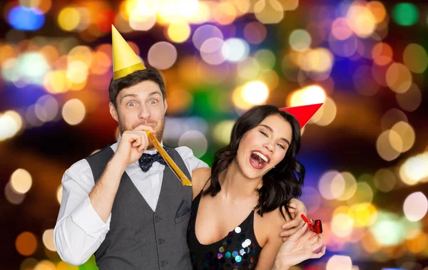 Glückliches Paar mit Party-Blowern, die Spaß haben — Stockfoto