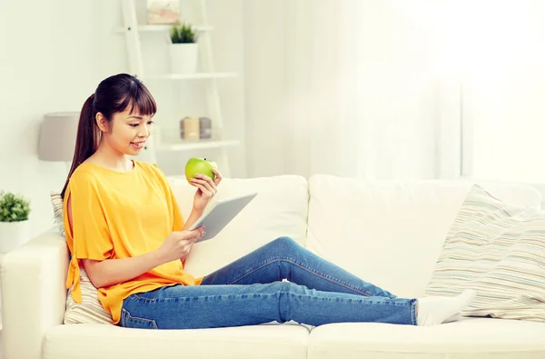 Feliz mujer asiática con tableta pc y manzana en casa —  Fotos de Stock