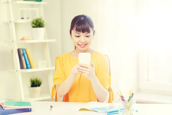 Happy young woman student with smartphone at home — Stock Photo, Image