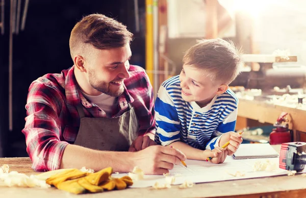 Lycklig far och son med blueprint på verkstad — Stockfoto