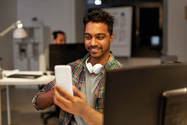 Hombre con smartphone que tiene videollamada en la oficina —  Fotos de Stock