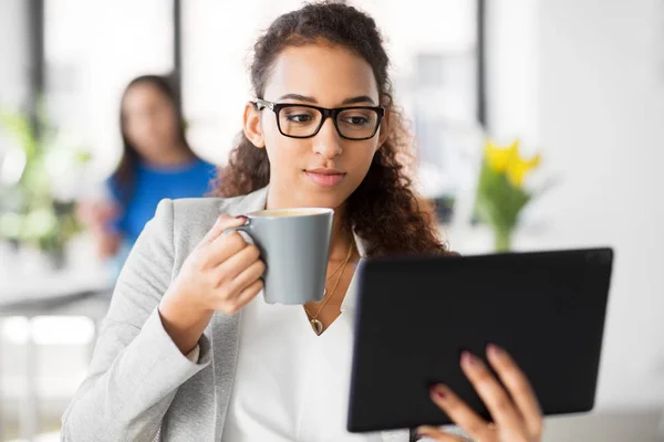 Empresaria con tablet pc y café en la oficina — Foto de Stock