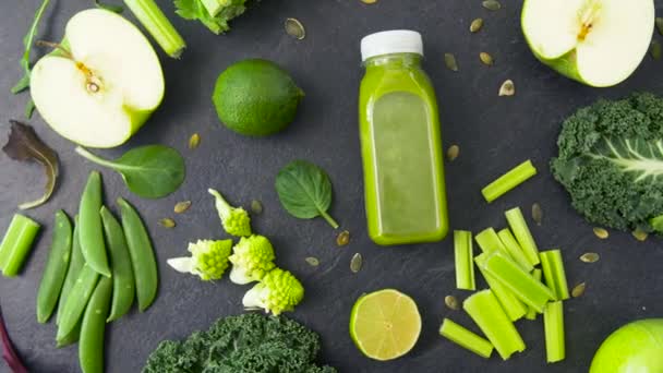 Butelka z zielony sok i warzywa na stole — Wideo stockowe