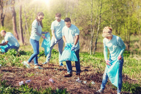 Voluntarios con bolsas de basura limpieza área del parque — Foto de Stock