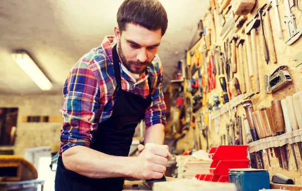 Carpintero trabajando con plano y madera en taller —  Fotos de Stock