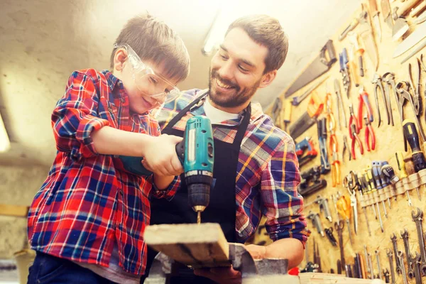 Pai e filho com broca trabalhando na oficina — Fotografia de Stock