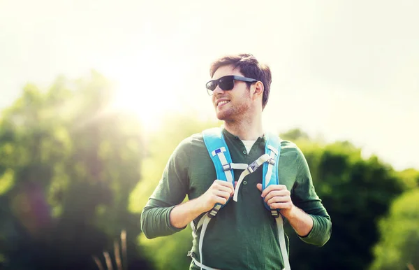 Glücklicher junger Mann mit Rucksack beim Wandern im Freien — Stockfoto