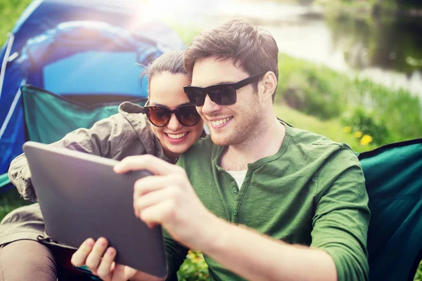 Happy couple with tablet pc at camping tent — Stock Photo, Image