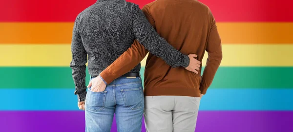 Close up of hugging male gay couple over rainbow — Stock Photo, Image