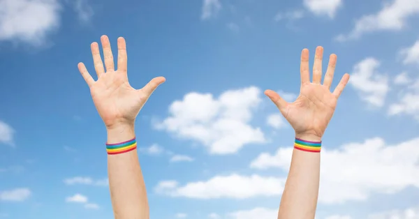 Mani con gay orgoglio arcobaleno braccialetti — Foto Stock