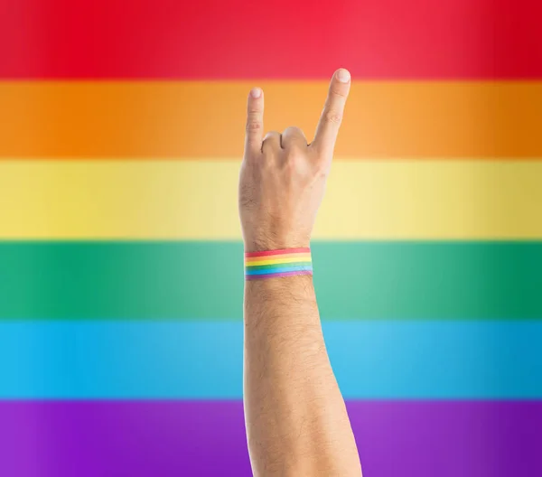 Mano con gay orgullo arco iris pulsera espectáculos rock — Foto de Stock