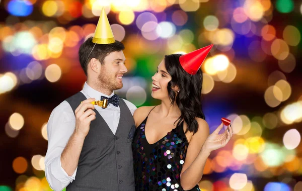 Feliz pareja con ventiladores de fiesta que se divierten — Foto de Stock