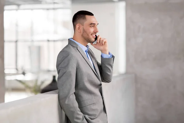 Businessman calling on smartphone at office — Stock Photo, Image