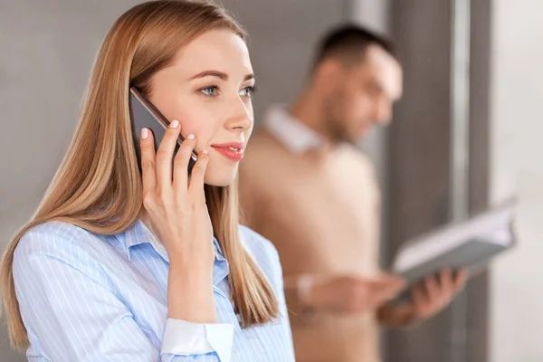 Empresária chamando no smartphone no escritório — Fotografia de Stock