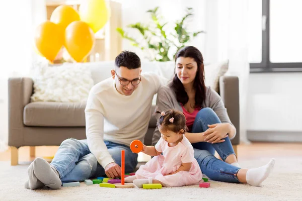 Babymeisje met ouders spelen met speelgoed van de piramide — Stockfoto