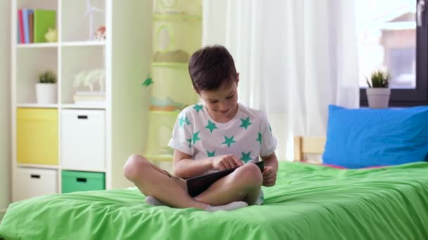 Niño sonriente con tablet PC en casa — Vídeos de Stock