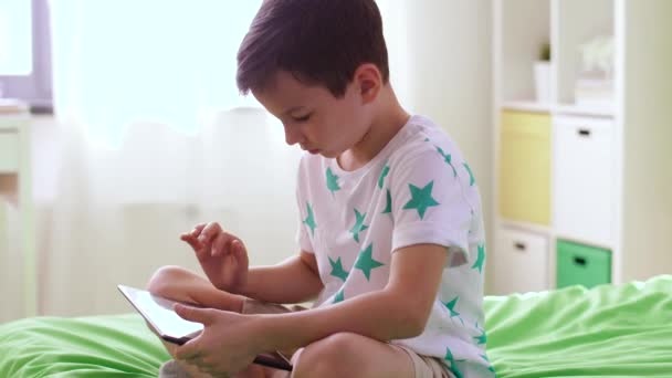 Улыбающийся мальчик с планшетным компьютером дома — стоковое видео