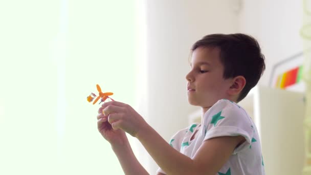 Niño feliz jugando con el juguete del avión en casa — Vídeos de Stock