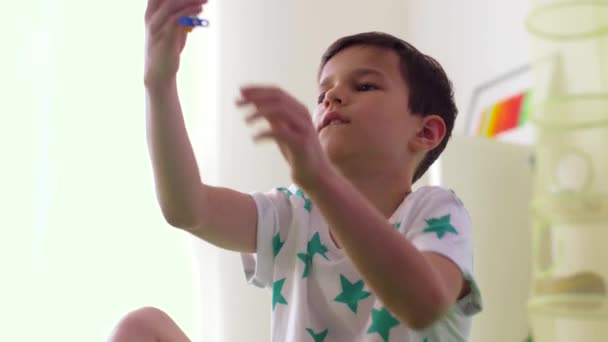 Счастливый мальчик играет с игрушкой самолета дома — стоковое видео