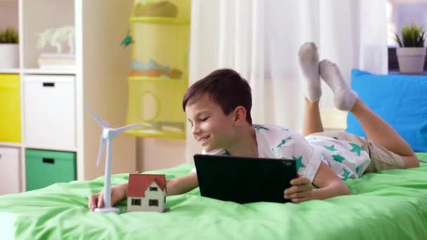 Boy with tablet pc and wind turbine toy at home — Stock Video