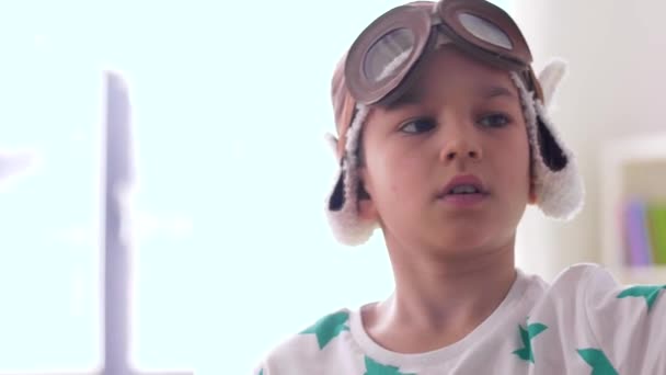 Boy in pilot hat playing with airplane toy at home — Stock Video