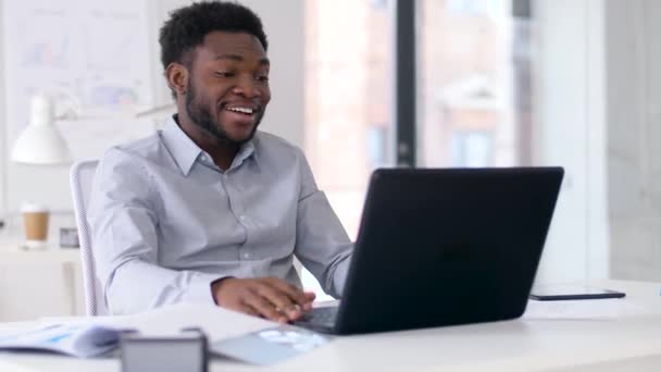 Hombre de negocios que tiene chat de vídeo en el ordenador portátil en la oficina — Vídeos de Stock