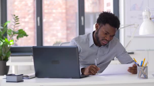 Uomo d'affari con computer portatile e documenti in ufficio — Video Stock