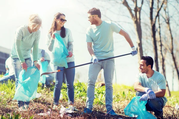 Voluntarios con bolsas de basura limpieza área del parque — Foto de Stock