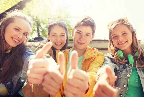 Amigos adolescentes ou estudantes mostrando polegares para cima — Fotografia de Stock