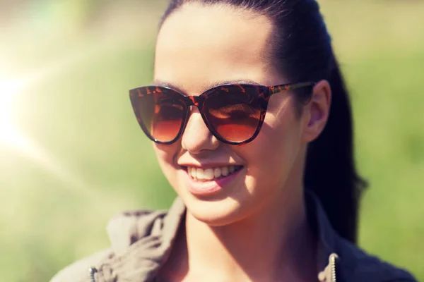 Cara de mujer joven feliz en gafas de sol al aire libre —  Fotos de Stock