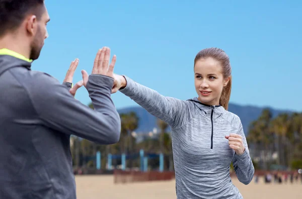 Gelukkige vrouw met coach bezig met staking buitenshuis — Stockfoto