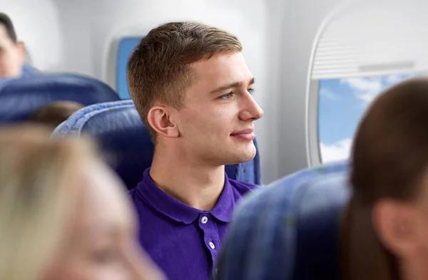 Feliz joven viajando en avión — Foto de Stock