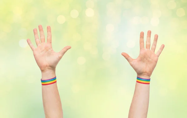 Manos con gay orgullo arco iris pulseras — Foto de Stock