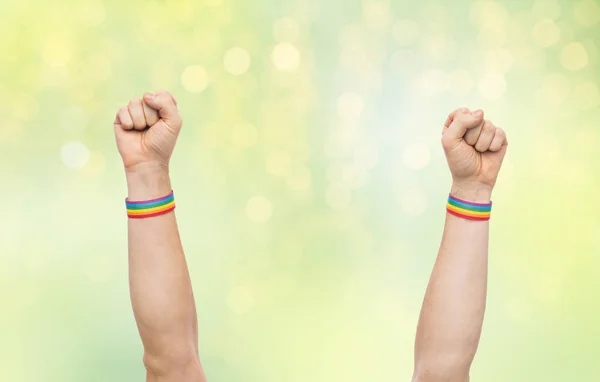 Manos con gay orgullo arco iris pulseras muestra puño — Foto de Stock