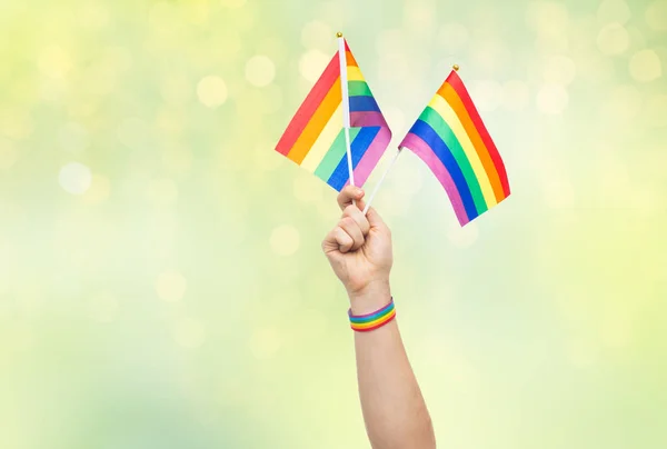 Mano con orgullo gay arco iris banderas y pulsera — Foto de Stock