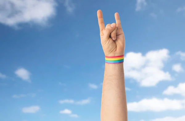 Hand met gay pride regenboog armband toont rock — Stockfoto