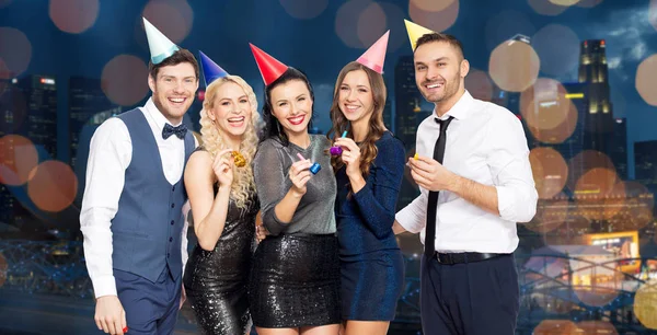 Happy friends with party blowers having fun — Stock Photo, Image