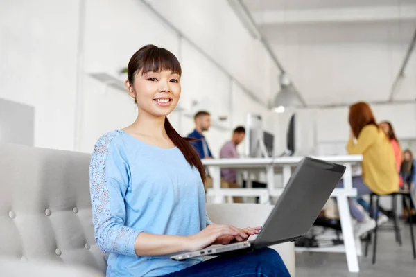 Feliz mujer asiática con portátil de trabajo en la oficina — Foto de Stock