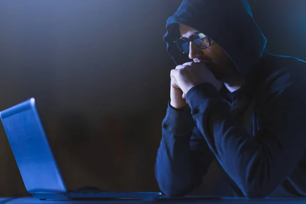 Хакер з ноутбуком в темній кімнаті — стокове фото