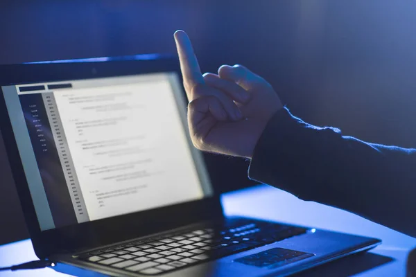 Хакер, що показує середній палець на ноутбук — стокове фото