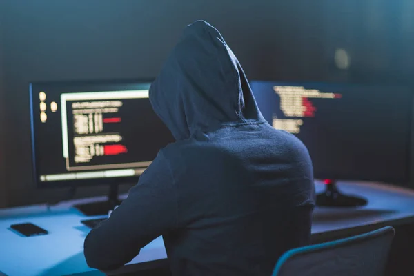 Cybercrime, Hacking und Technologiekonzept - männliche Hacker im Darkroom schreiben Code oder verwenden Computervirus-Programm für Cyber-Angriffe — Stockbild Hacker nutzt Computervirus für Cyber-Angriff — Stockfoto
