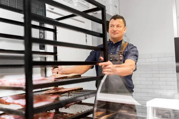 Seller with smoking tray at fish shop — Stock Photo, Image