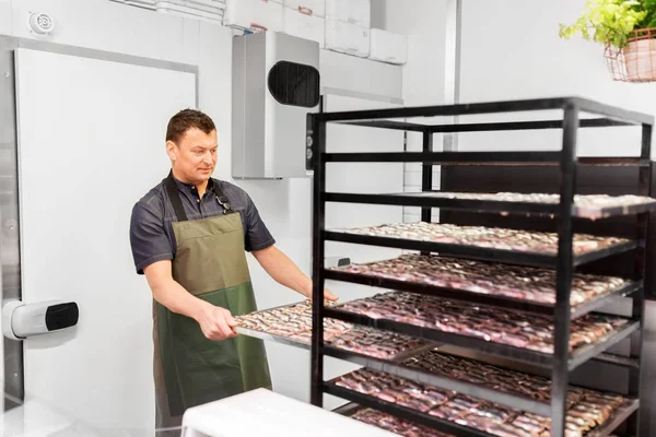 Mann mit Tablett in Fischladen oder Räucherei — Stockfoto