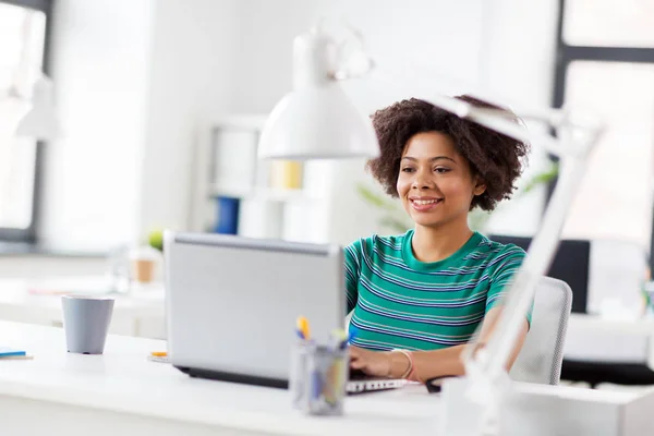 Happy african woman with laptop computer at office — Stock Photo, Image
