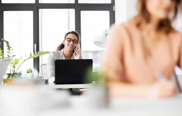 Mujer de negocios llamando en el teléfono inteligente en la oficina — Foto de Stock